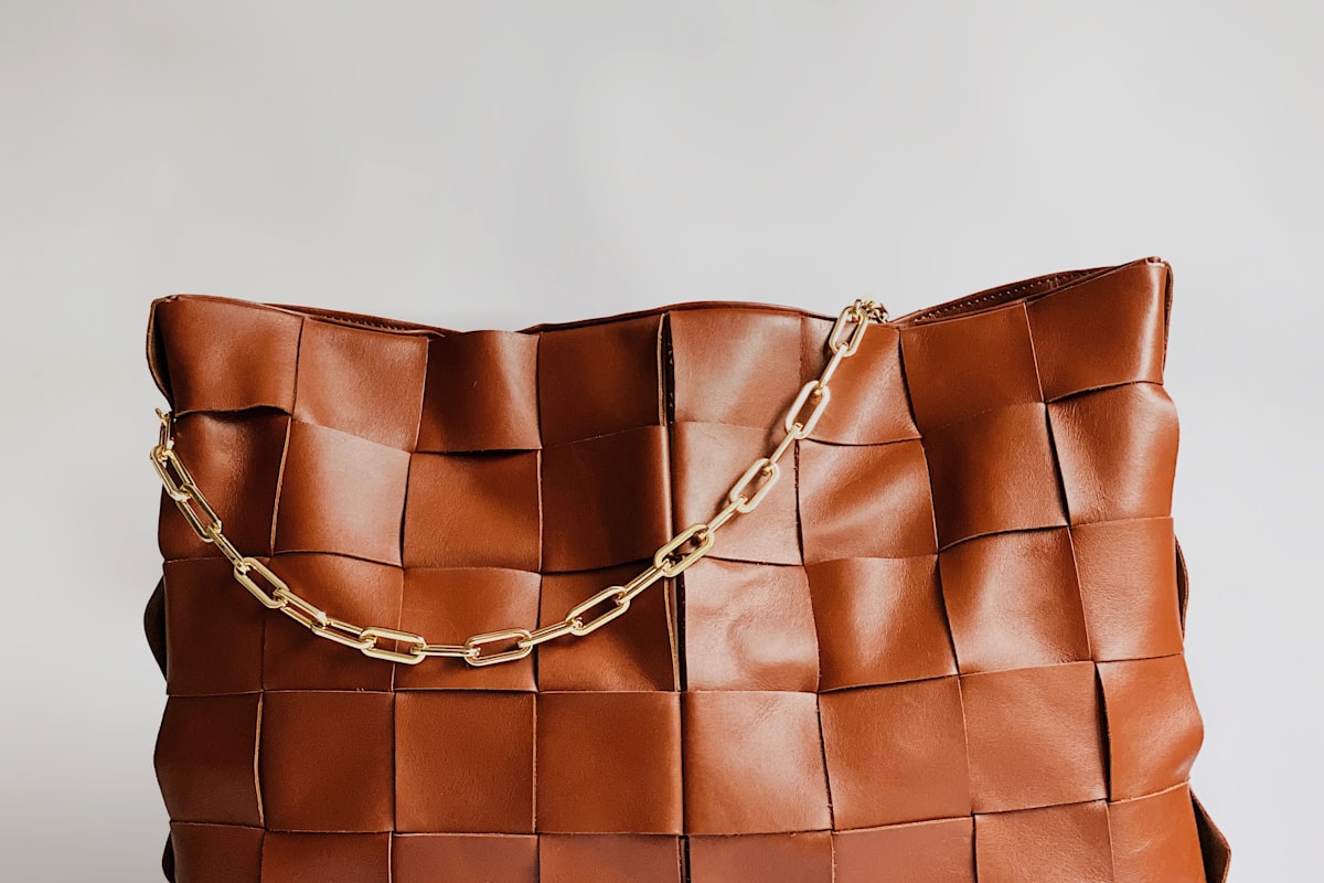 Woven tan leather handbag with gold chain after conditioning